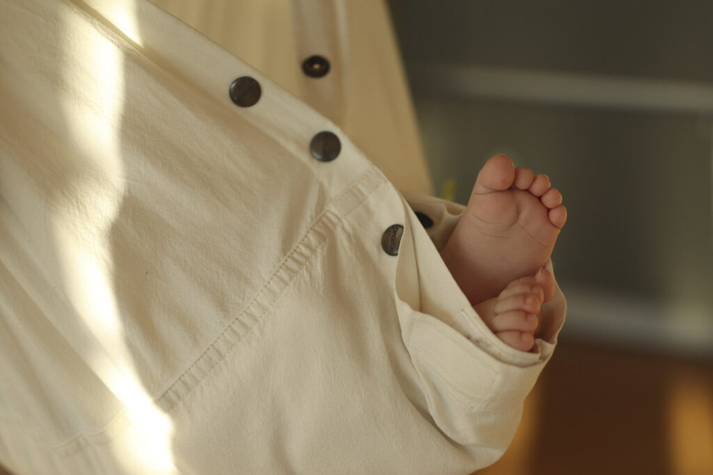 Füßchen, die aus einer Federwiege gestreckt werden. Das Licht fällt wunderbar in den Raum.