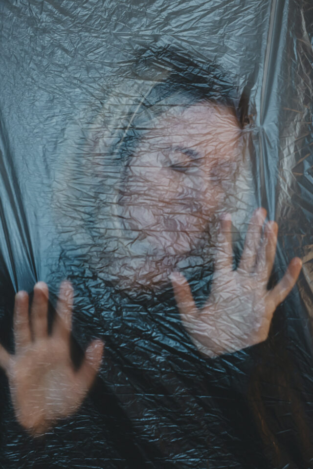 Ein Frauenportrait hinter eine zerknitterten Folie.