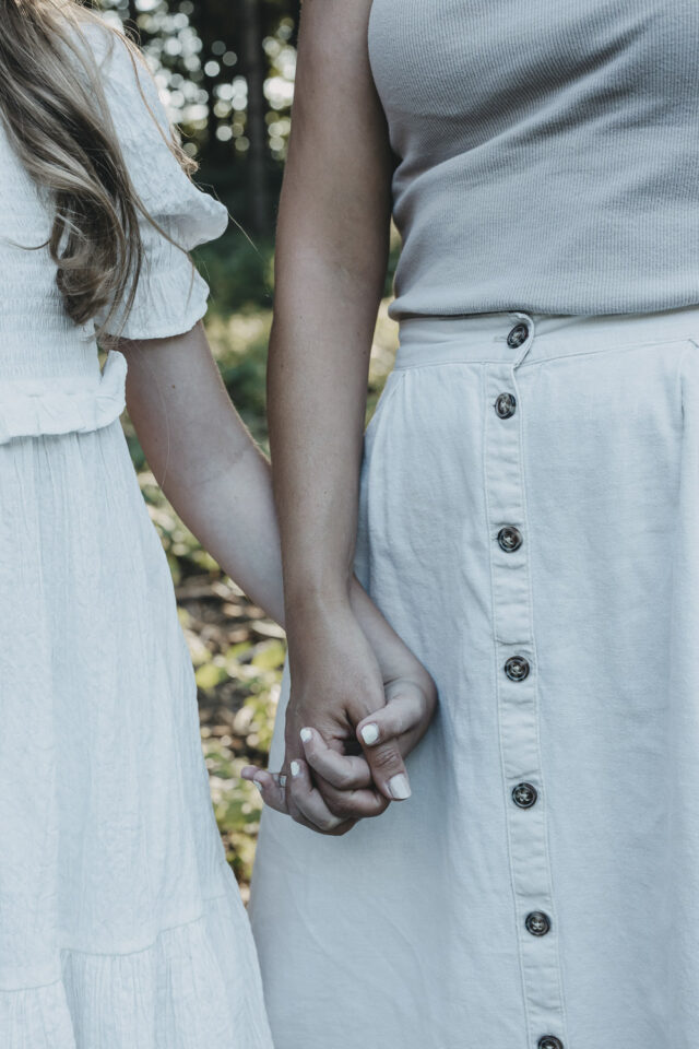 Hände von Mama und Tochter, die sich halten.