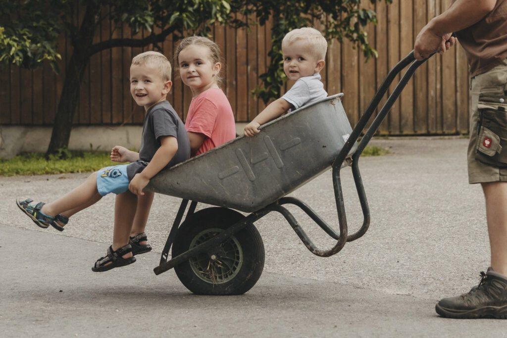 Drei Kinder sitzend ein einer Schreibtruhe.
