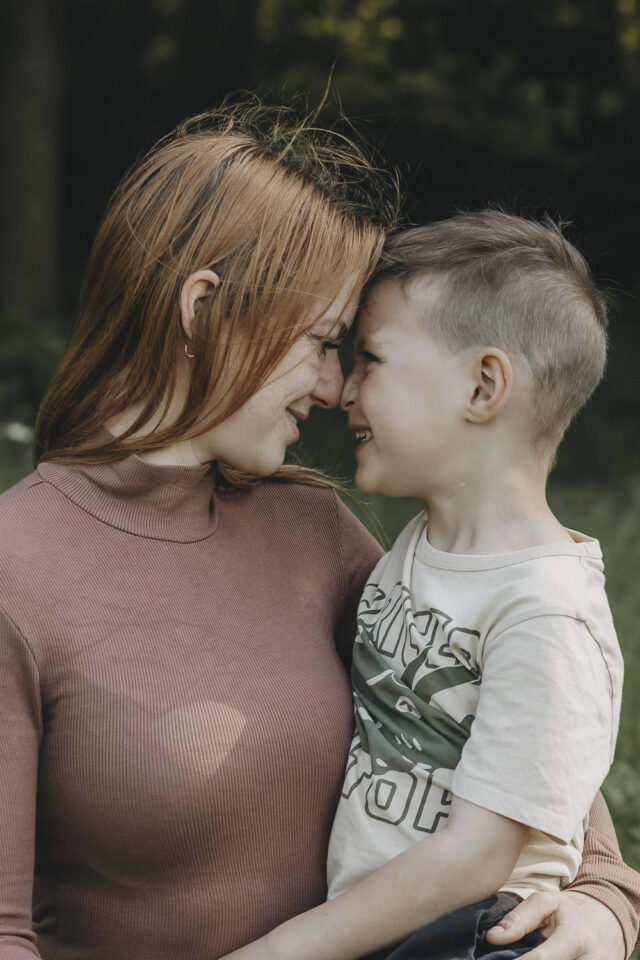 Mutter mit ihrem vierjährigen Sohn, sie sitzen sich gegenüber, schauen sich tief in die Augen und berühren sich mit den Nasenspitzen.