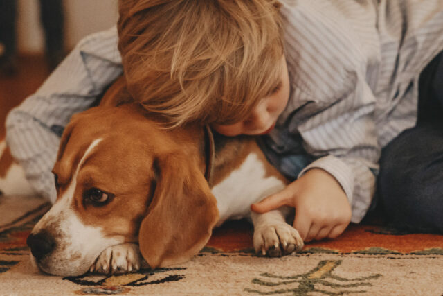 Kind, das mit einem Hund kuschelt.
