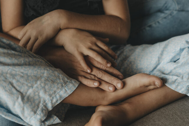 Hände und Füße eines Mädchens und ihrer Mutter.