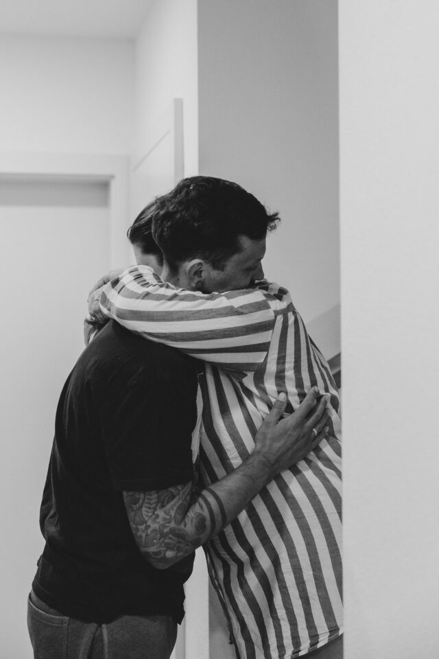 Schwarz-Weiß-Bild. Gebärdende umarmt ihren Mann.