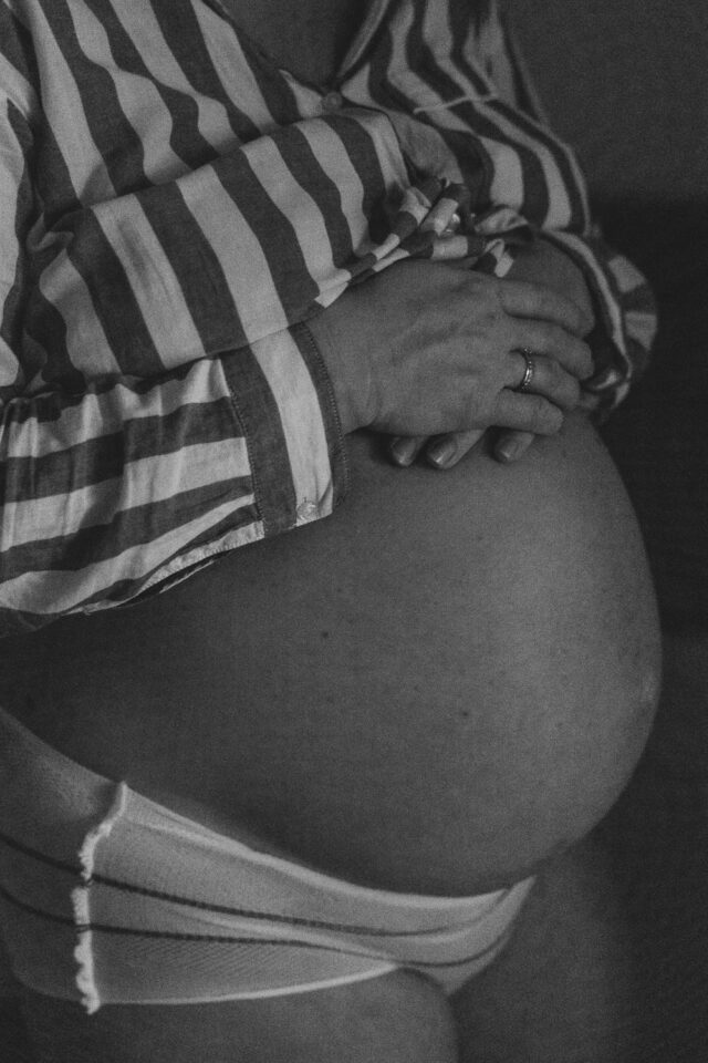 Schwangere Frau hält ihren Babybauch während der ersten Wellen.