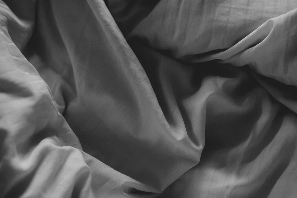 Schwarz-Weiß-Bild. Verknitterte Falten einer Bettwäsche.