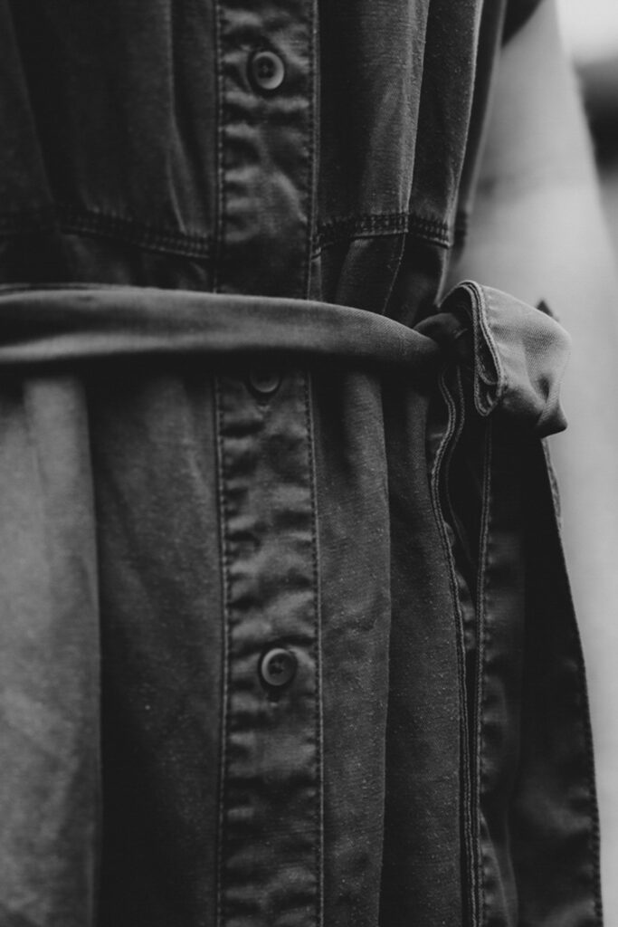 Schwarz-Weiß-Bild. Frauenhüfte die ein festgeschnürtes Kleid zeigt.