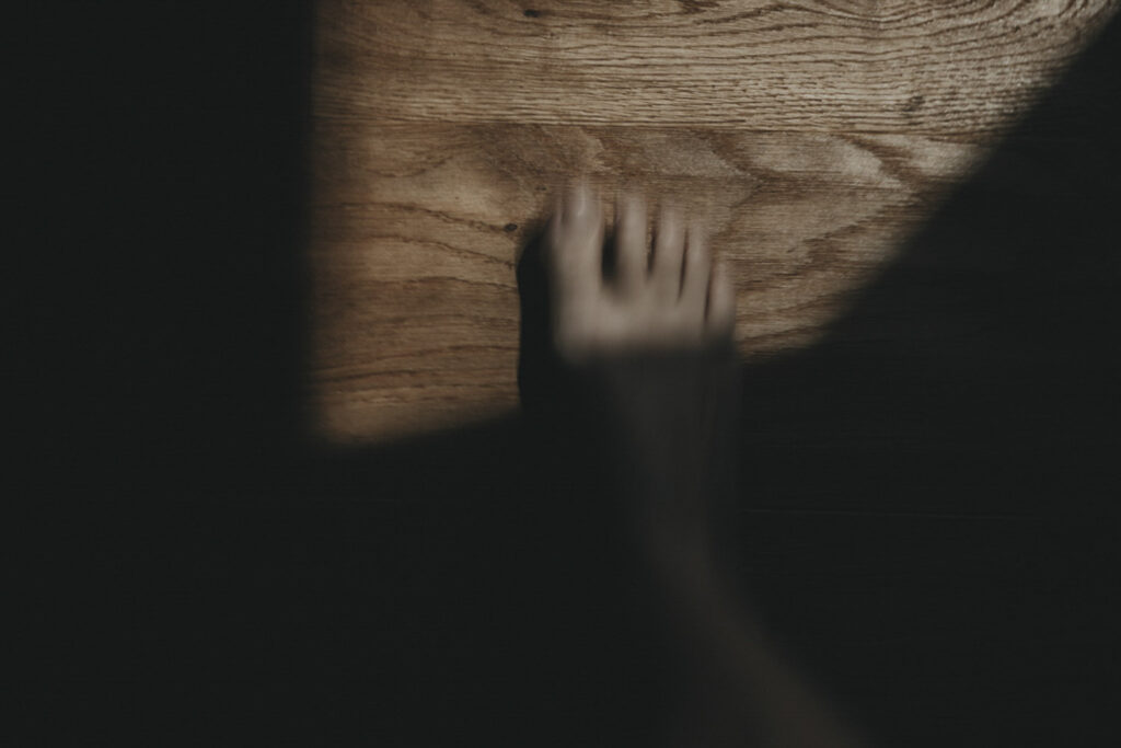 Fuß, der in ein Lichtfenster eintritt. Durch die Bewegung leicht verschwommen.