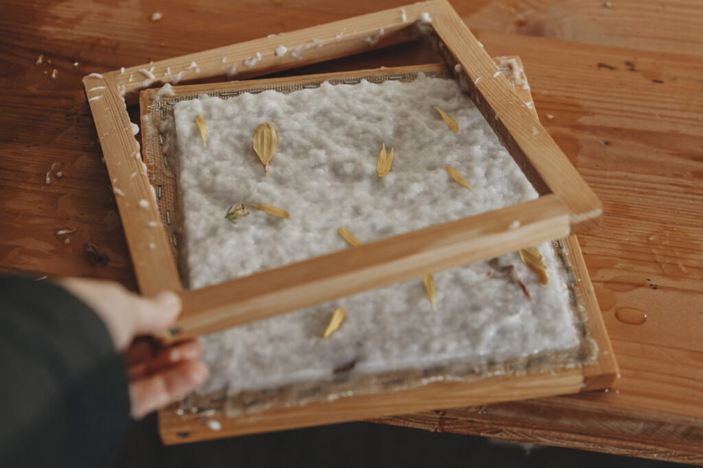 Rahmen der gerade abgenommen wird, vom geschöpften Papier.