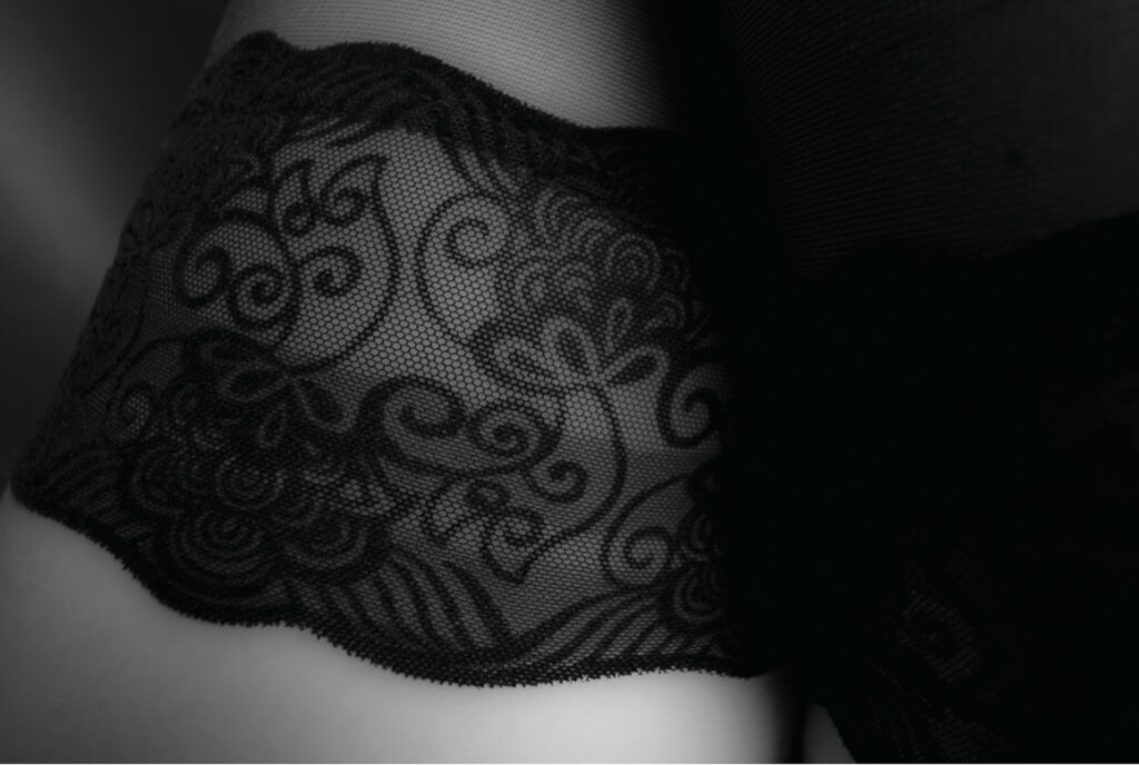Schwarz-Weiß-Bild. Frauenstrümpfe mit schwarzer Spitze, angeschnitten.