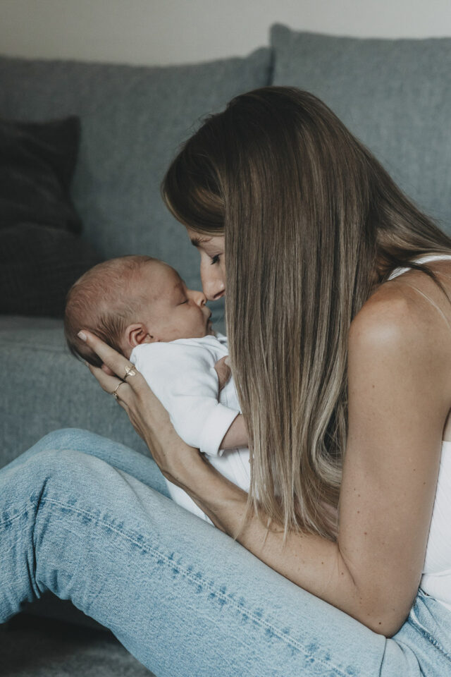 Mutter und Baby berühren sich mit den Nasen, beide haben geschlossene Augen.