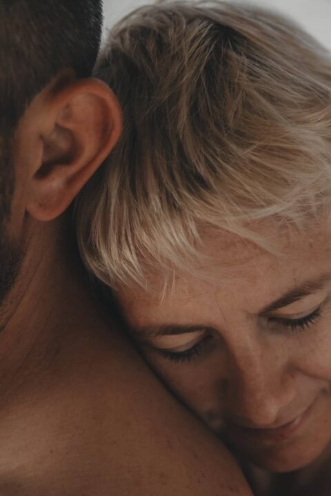 Ein Frauenkopf der sich an der Schulter eines Mannen anlehnt.